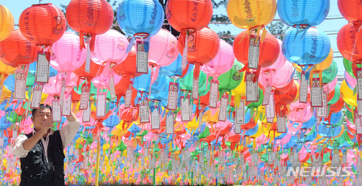 [완주=뉴시스] 김얼 기자 = 부처님 오신 날을 이틀 앞둔 13일 전북 완주군 송광사에서 한 불자가 연등에 소원지를 달고 있다. 2024.05.13. pmkeul@newsis.com