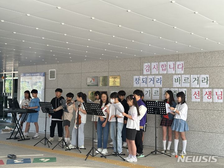 [화성=뉴시스]화성시 세정초등학교 학생들이 스승의 날을 하루 앞둔14일 버스킹 공연으로 선생님의 출근길을 맞이하고 있다.(사진=화성오산교육지원청 제공)2024.05.14.photo@newsis.com