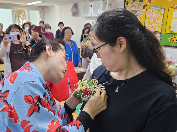 [서울=뉴시스] 이태성 기자 = 스승의날을 하루 앞둔 14일 오후 서울 마포구 일성여자고등학교에서 한 만학도 학생이 선생님에게 카네이션을 달아주고 있다. 2024.05.14. victory@newsis.com *재판매 및 DB 금지