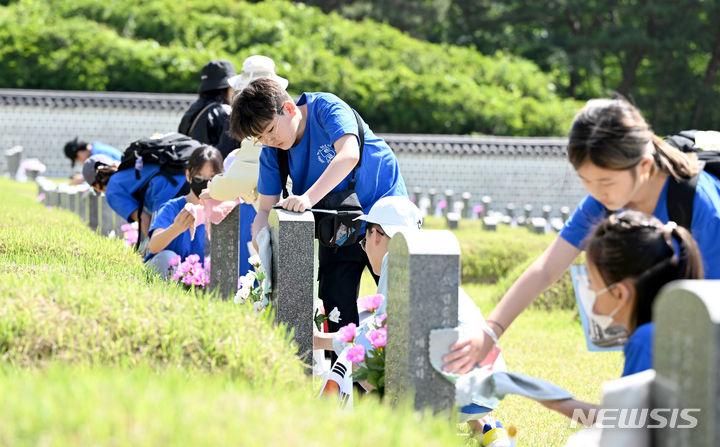 [광주=뉴시스] 김혜인 기자 = 5·18민주화운동 44주기를 나흘 앞둔 14일 오전 광주 북구 국립5·18민주묘지에서 학생들이 희생자를 기리며 묘비를 닦고 있다. 2024.05.14. hyein0342@newsis.com