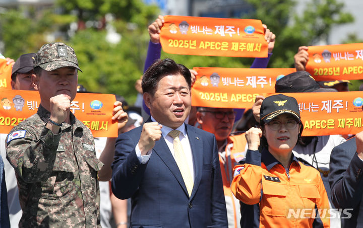 [서귀포=뉴시스] 우장호 기자 = 오영훈(가운데) 제주지사가 14일 오전 제주 서귀포시 강정동 제주민군복합형 관광미항 김영관센터 종합운동장에서 열린 '2024 전도 의용소방대 소방기술 경연대회'에 참석해 APEC 정상회의 제주유치 구호를 외치고 있다. 2024.05.14. woo1223@newsis.com