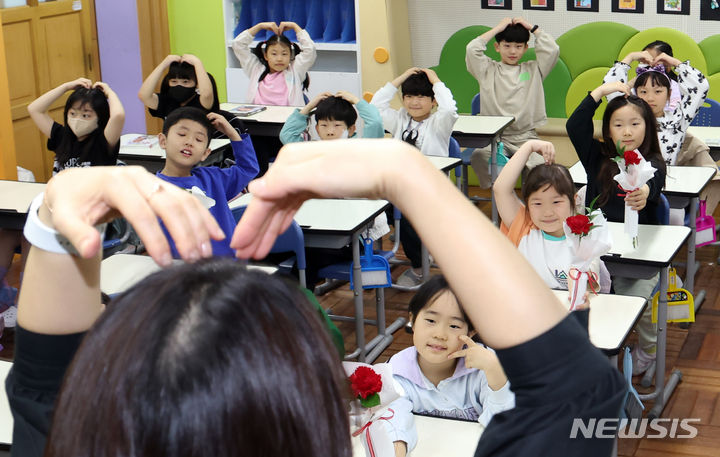 [부산=뉴시스] 하경민 기자 = 스승의 날을 하루 앞둔 지난 5월14일 부산 남구 용소초등학교 2학년 교실에서 학생들이 담임 교사에게 손하트를 만들어 보이고 있다. 2024.05.14. yulnetphoto@newsis.com