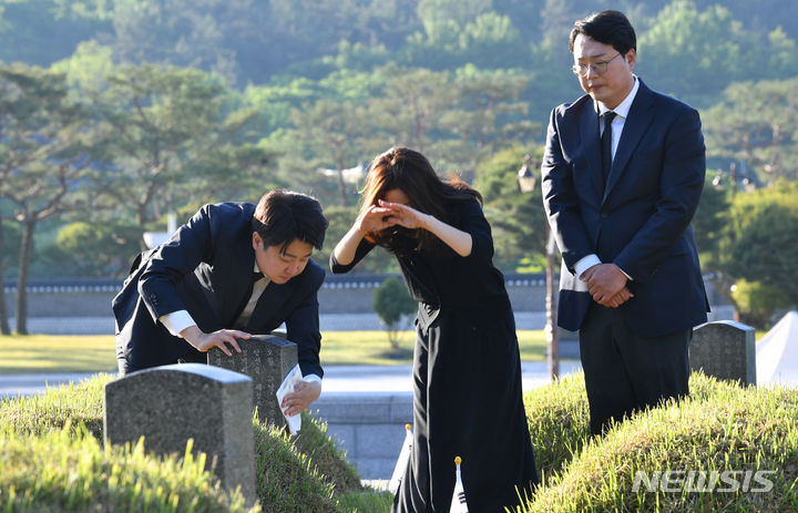 [광주=뉴시스] 변재훈 기자 = 개혁신당 이준석 대표가 5·18민주화운동 44주기를 사흘 앞둔 15일 오전 광주 북구 운정동 국립 5·18민주묘지에서 이주영·천하람 국회의원 당선인과 함께 열사 묘역을 일일이 돌며 헌화하고 묘비를 닦고 있다. 이 대표 일행은 이날 새벽 경남 김해에서 가져온 국화를 5·18민주묘지 내 모든 안장 묘 986기에 헌화한다. 2024.05.15. wisdom21@newsis.com