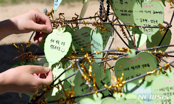 [대구=뉴시스] 이무열 기자 = 부처님 오신 날인 15일 대구 동구 동화사에서 한 불자가 소원지를 달고 있다. 2024.05.15. lmy@newsis.com