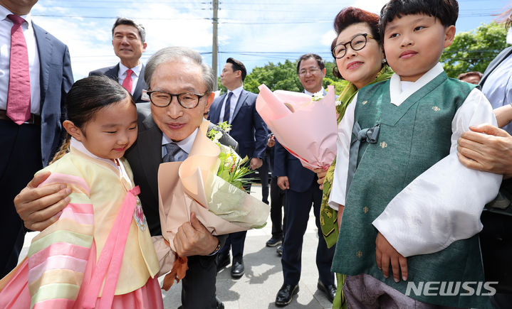 [포항=뉴시스] 이무열 기자 = 이명박 전 대통령과 김윤옥 여사가 16일 경북 포항시 북구 흥해읍 덕실마을에서 화동에게 꽃다발을 받고 있다. 2024.05.16. lmy@newsis.com