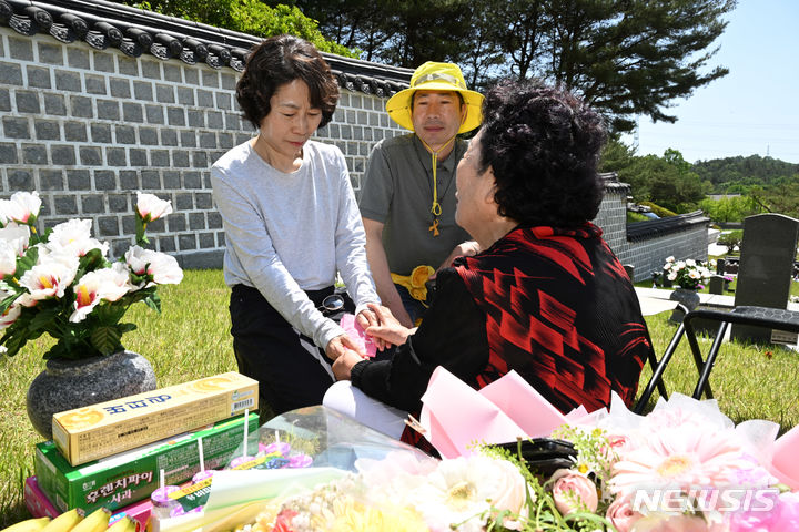 [광주=뉴시스] 박기웅 기자 = 18일 광주 북구 운정동 국립5·18민주묘지에서 고(故) 이창현군의 어머니 김말임 여사가 세월호 참사 희생자 이창현군의 어머니 최순화씨의 손을 잡고 위로하고 있다. 2024.05.18. pboxer@newsis.com