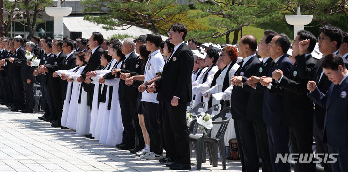 [광주=뉴시스] 조수정 기자 = 윤석열 대통령이 18일 광주 북구 국립5·18민주묘지에서 열린 제44주년 5·18민주화운동 기념식에서 오월어머니회 등 참석자와 손을 잡고 임을 위한 행진곡을 제창하고 있다. 오른쪽은 정당 대표자들. 오른쪽부터 이석현 새로운미래 비상대책위원장, 김준우 정의당 대표, 박찬대 더불어민주당 원내대표, 추경호 국민의힘 원내대표, 이재명 더불어민주당 대표, 황우여 국민의힘 비상대책위원장. 2024.05.18. chocrystal@newsis.com