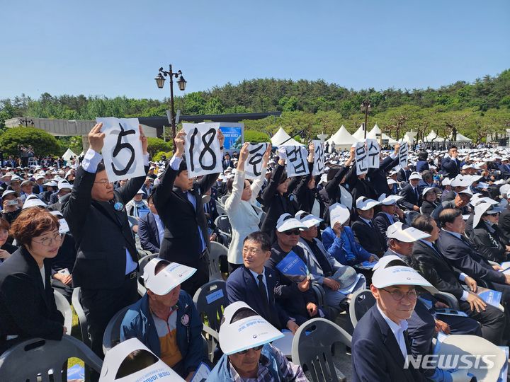 [광주=뉴시스] 광주시의회 5·18특별위원회 소속 시의원 8명이 18일 오전 광주 북구 국립 5·18민주묘지에서 열린 5·18민주화운동 44주년 기념식 윤석열 대통령의 기념사 도중 '5·18 헌법전문 수록'을 촉구하는 기습 손팻말 시위를 벌이고 있다. (사진=광주전남사진기자단) 2024.05.18. photo@newsis.com