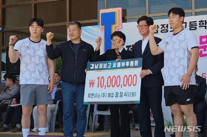 [창원=뉴시스]창원에 본사를 둔 로만시스㈜ 장정식(오른쪽서 두 번째) 회장이 19일 모교인 경남정보고를 방문해 씨름부 후원금1000만 원을 전달하고 있다.(사진=로만시스 제공) 2024.05.19. photo@newsis.com