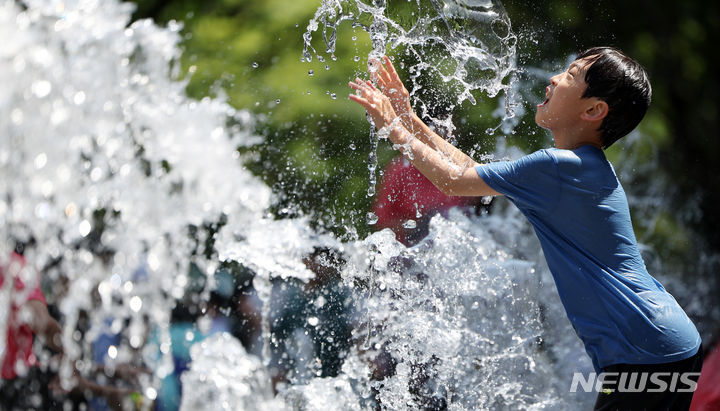 [서울=뉴시스] 김명년 기자 = 초여름 더위가 찾아온 지난 19일 오후 서울 종로구 광화문광장 분수대에서 한 아이가 물놀이를 하고 있다. 2024.05.19. kmn@newsis.com