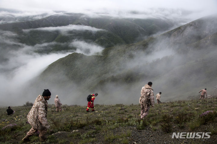 [바르자간=AP/뉴시스] 20일(현지시각) 이란 북서부 바르자간에서 에브라힘 라이시 대통령 일행이 탑승한 헬기가 추락한 가운데 구조대원들이 수색 작업을 하고 있다. 2024.05.21.