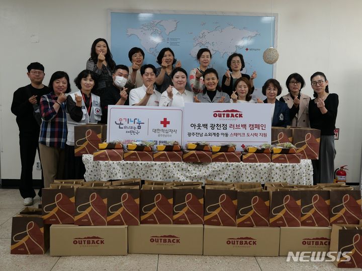 [서울=뉴시스] 이나은 아웃백 광주광천점 점주(첫 번째 줄 좌측 6번째)와 임직원이 대한적십자사 광주전남지사 및 지역아동센터 관계자들과 기념사진을 촬영하고 있다. (사진= bhc그룹 제공)