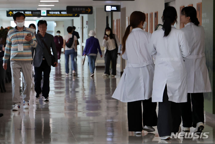 [서울=뉴시스] 이영환 기자 = 20일 서울의 한 대학병원에서 의료진이 이동하고 있다.   전공의는 전문의의 수련 및 자격 인정 등에 관한 규정에 따라 추가 수련 기간이 3개월을 초과하면 전문의 자격 취득 시기가 1년 지연된다. 이번 의대 증원에 반발한 전공의들은 지난 2월19일부터 집중적으로 현장을 이탈했기 때문에 이번 주 내로 복귀하지 않으면 이들의 전문의 취득은 1년 지연된다. 2024.05.20. 20hwan@newsis.com