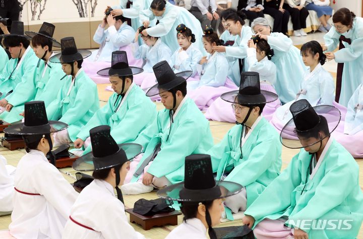[부산=뉴시스] 하경민 기자 = 제52회 성년의 날인 20일 오후 부산 사상구 부산시여성문화회관 대강당에서 열린 '전통 성년례'에 참가한 남녀 성년자 22명이 갓을 쓰고 비녀를 꽂는 의식인 관례와 계례를 하고 있다. 2024.05.20. yulnetphoto@newsis.com