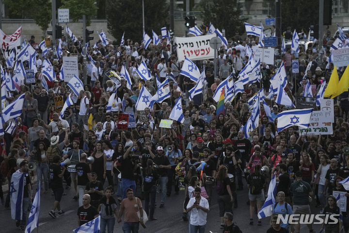 [예루살렘=AP/뉴시스] 20일(현지시각) 이스라엘 예루살렘에 있는 이스라엘 의회(크네세트) 밖에서 가자지구에 억류된 인질들의 석방을 촉구하는 반정부 시위대가 국기를 흔들며 시위하고 있다. 2024.05.26.