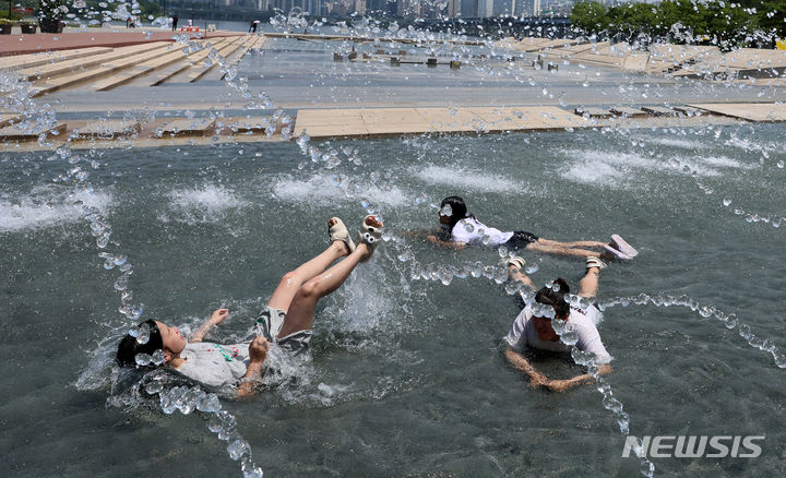 [서울=뉴시스] 이영환 기자 = 초여름 날씨를 보인 21일 오후 서울 영등포구 여의도한강공원 물빛광장을 찾은 학생들이 물놀이를 하고 있다. 2024.05.21. 20hwan@newsis.com