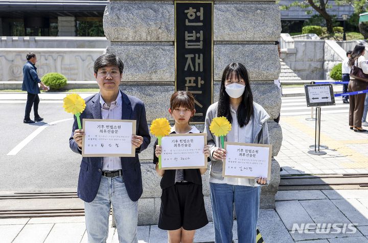 [서울=뉴시스] 정병혁 기자 =  청소년·시민·아기 기후소송 대표자들이 21일 서울 종로구 헌법재판소 앞에서 열린 기후 헌법소원 마지막 공개변론에 앞서 기후 헌법소원 최후진술문을 들고 있다. 2024.05.21. jhope@newsis.com