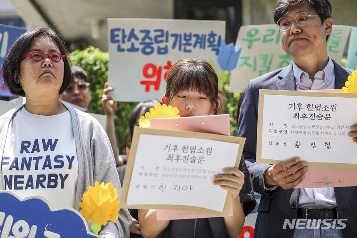 [서울=뉴시스] 정병혁 기자 = 21일 서울 종로구 헌법재판소 앞에서 열린 기후 헌법소원 마지막 공개변론 공동 기자회견에서 참가자들이 피켓을 들고 있다. 2024.05.21. jhope@newsis.com