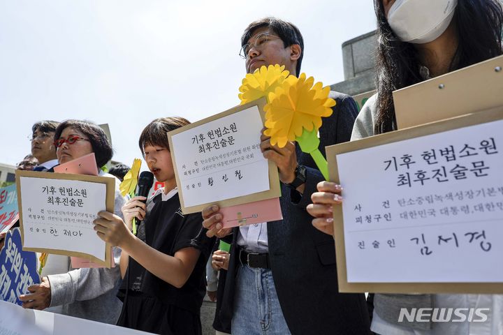 [서울=뉴시스] 정병혁 기자 =  아기 기후소송 대표 한제아 어린이가 21일 서울 종로구 헌법재판소 앞에서 열린 기후 헌법소원 마지막 공개변론 공동 기자회견에서 기자회견문을 읽고 있다. 2024.05.21. jhope@newsis.com