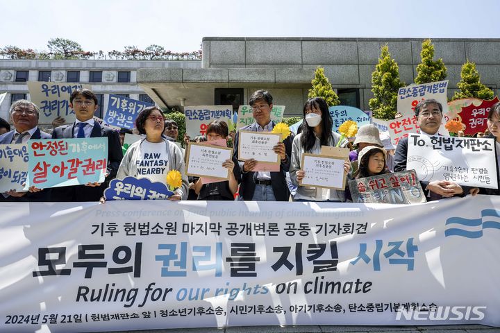 [서울=뉴시스] 정병혁 기자 = 21일 서울 종로구 헌법재판소 앞에서 열린 기후 헌법소원 마지막 공개변론 공동 기자회견에서 참가자들이 피켓을 들고 있다. 2024.05.21. jhope@newsis.com