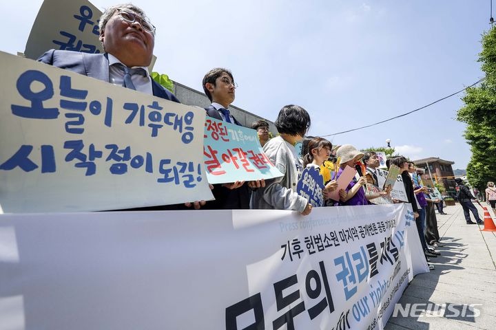 [서울=뉴시스] 정병혁 기자 = 21일 서울 종로구 헌법재판소 앞에서 열린 기후 헌법소원 마지막 공개변론 공동 기자회견에서 참가자들이 피켓을 들고 있다. 2024.05.21. jhope@newsis.com