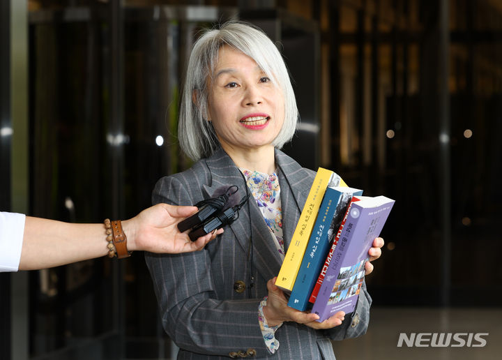 [서울=뉴시스] 황준선 기자 = 권성희 변호사가 21일 오후 서울 서초구 서울중앙지방검찰청에서 열린 참고인 조사에 출석하며 지난 2022년 윤석열 대통령 부부가 살던 서울 서초구 아파트 분리수거장에서 김건희 여사가 선물 받은 것으로 추정되는 최재형 목사의 저서 등을 들어보이고 있다. 2024.05.21. hwang@newsis.com