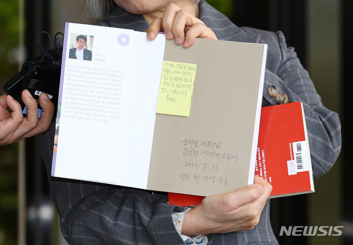 [서울=뉴시스] 황준선 기자 = 권성희 변호사가 21일 오후 서울 서초구 서울중앙지방검찰청에서 열린 참고인 조사에 출석하며 지난 2022년 윤석열 대통령 부부가 살던 서울 서초구 아파트 분리수거장에서 김건희 여사가 선물 받은 것으로 추정되는 최재형 목사의 저서 등을 들어보이고 있다. 2024.05.21. hwang@newsis.com