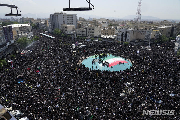 [테헤란=AP/뉴시스] 22일(현지시각) 이란 수도 테헤란에서 고 에브라힘 라이시 대통령과 헬기 추락 사고 희생자들의 영결식이 열려 수많은 이란 사람이 참석하고 있다. 고인들을 추모하는 수만 인파가 테헤란을 통과하는 운구행렬을 따른 것으로 알려졌다. 2024.05.22.