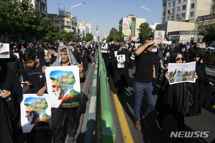 [테헤란=AP/뉴시스] 22일(현지시각) 이란 수도 테헤란에서 열린 고 에브라힘 라이시 대통령과 헬기 추락 사고 희생자들의 장례식에 시민들이 참석하고 있다. 2024.05.23.
