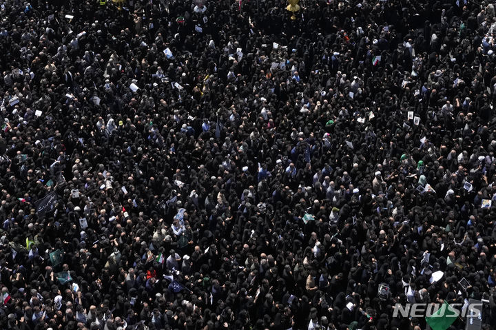 [테헤란=AP/뉴시스] 22일(현지시각) 이란 수도 테헤란에서 열린 고 에브라힘 라이시 대통령과 헬기 추락 사고 희생자들의 장례식에 시민들이 참석하고 있다. 2024.05.23.