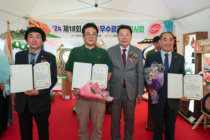 [당진=뉴시스] 22일 당진시청 일원에서 옥외광고 산업 육성 및 발전을 위해 충남옥외광고협회 당진시지부가 '제18회 당진시 우수광고물 전시회'를 연 가운데 대상 등을 차지한 수상자가 상장을 들고 오성환 시장(왼쪽 3번째)과 기념 촬영을 하고 있다. (사진=당진시 제공) 2024.05.22. *재판매 및 DB 금지