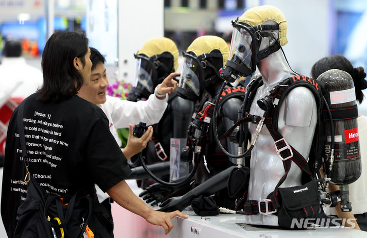 [대구=뉴시스] 이무열 기자 = 지난 2024년 대구 북구 엑스코에서 열린 ‘국제소방안전박람회’를 찾은 관람객이 스마트 공기호흡기를 살펴보고 있다. 2024.05.22. lmy@newsis.com **위 사진은 기사 내용과 무관합니다. 