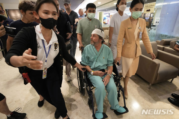 [AP/뉴시스] 싱가포르항공 보잉기에 탔다가 난기류로 부상해 방콕 병원에 입원한 호주 환자가 23일 기자들과 이야기하고 있다 