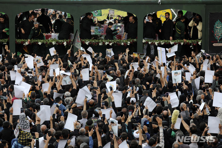 [마슈하드=AP/뉴시스] 23일(현지시각) 에브라힘 라이시 이란 대통령의 고향인 이란 마슈하드에서 라이시 대통령의 사진을 든 추도객들이 고인의 운구 차량 주변을 에워싸고 있다. 2024.05.24.