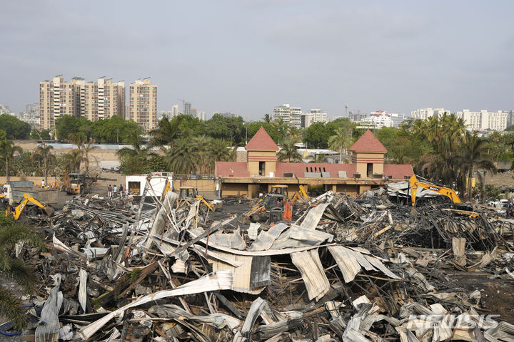 [라지코트=AP/뉴시스]인도 서부 구자라트주 라지코트시의 한 유원지 게임센터에서 화재가 발생한 다음 날인 26일(현지시각) 중장비들이 불에 탄 잔해를 치우고 있다. 2024.05.26.