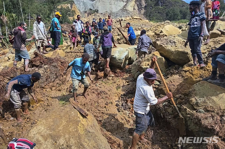 [AP/뉴시스] 26일 파푸아 뉴기니의 얌발리 지역에서 주민들이 산사태 진흙들을 헤미고 수색구조 활동을 하고 있다