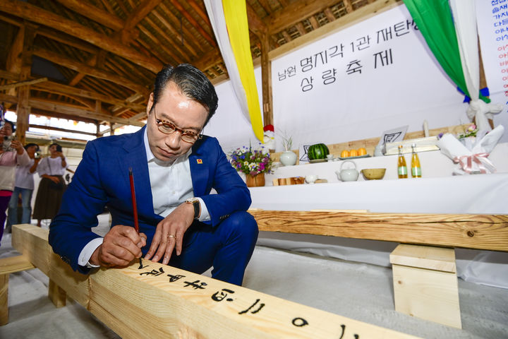 남원시가 광한루원 일원의 기존 한옥 요식업소 '종가집'을 '명지호텔'로 리모델링한다며 27일 건물의 상량식이 열렸다고 밝혔다. 최경식 시장이 건물의 보존과 이후 명지호텔의 번영을 기원하는 상량문을 쓰고 있다. *재판매 및 DB 금지