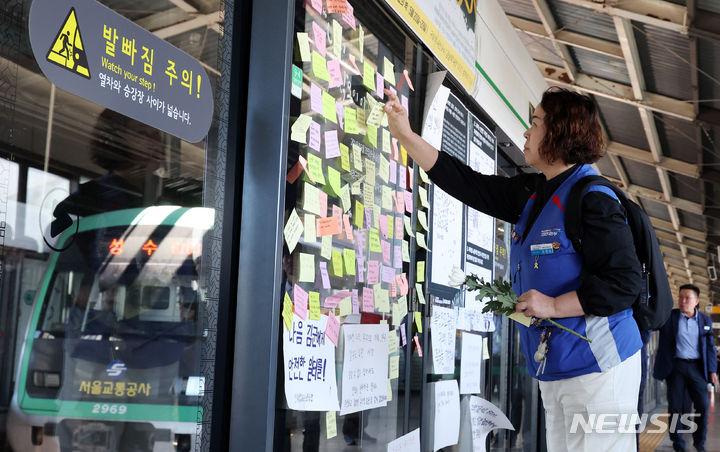 [서울=뉴시스] 추상철 기자 = 28일 오전 서울 광진구 구의역 승강장에서 열린 '구의역 산재사망 참사 8주기' 누구에게도 차별 없이, 안전한 공공교통을 요구하는 재해 참사 현장 함께 돌아보기(다크투어)에서 참가자가 추모메시지를 부착하고 있다. 2024.05.28. scchoo@newsis.com