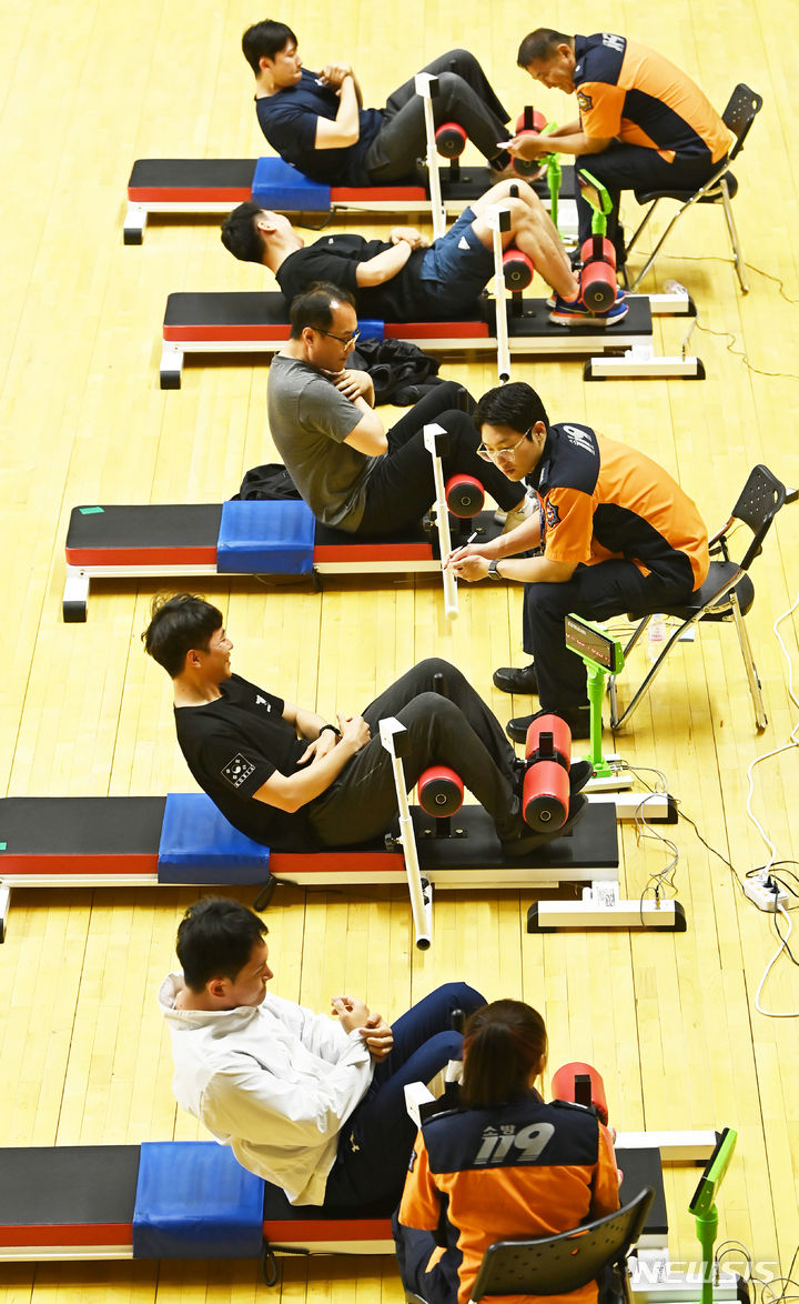 [수원=뉴시스] 김종택 기자 = 2024년도 경기도 소방공무원 체력검정이 실시된 28일 경기도 수원시 칠보체육관에서 응시생들이 윗몸일으키기 테스트를 받고 있다. 2024.05.28. jtk@newsis.com