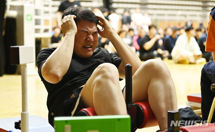 [수원=뉴시스] 김종택 기자 = 2024년도 경기도 소방공무원 체력검정이 실시된 28일 경기도 수원시 칠보체육관에서 응시생들이 윗몸일으키기 테스트를 받고 있다. 2024.05.28. jtk@newsis.com