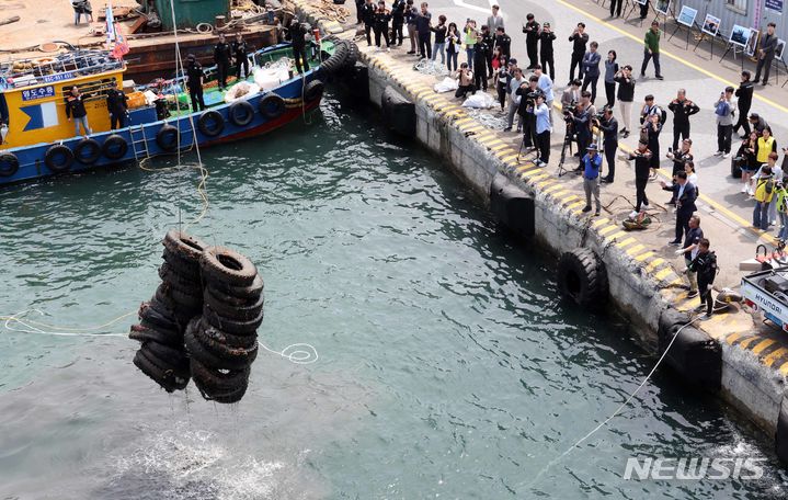 [부산=뉴시스] 하경민 기자 = 제29회 바다의 날(5월31일)을 앞두고 28일 부산 영도구 봉래동 물양장에서 중앙해양특수구조단, 한국해양구조협회 전문 다이버가 수거한 폐타이어 등 해양 쓰레기를 크레인을 동원해 옮기고 있다. 이날 행사에는 19개 기관·단체와 시민 등 160여 명이 참여해 해양환경정화 활동을 펼쳤으며, 총 98t에 달하는 해양 쓰레기를 수거했다. 2024.05.28. yulnetphoto@newsis.com