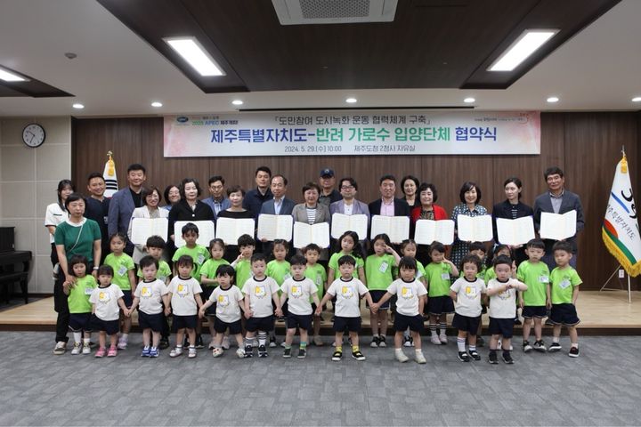 [제주=뉴시스] 29일 제주도청 2청사 자유실에서 열린 제주도-반려 가로수 입양단체 협약식에 참석한 기관·단체 관계자와 어린이들이 기념 촬영을 하고 있다. (사진=제주도 제공) 2024.05.29. photo@newsis.com *재판매 및 DB 금지