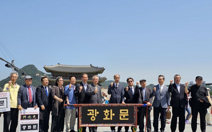 [서울=뉴시스] 광화문 한글 현판 환영 기자회견에서 한글로 된 현판을 보이고 있는 김주원 한글학회 회장(오른쪽에서 여섯 번째)의 모습(사진=한글학회 제공) 2024.05.29. photo@newsis.com *재판매 및 DB 금지