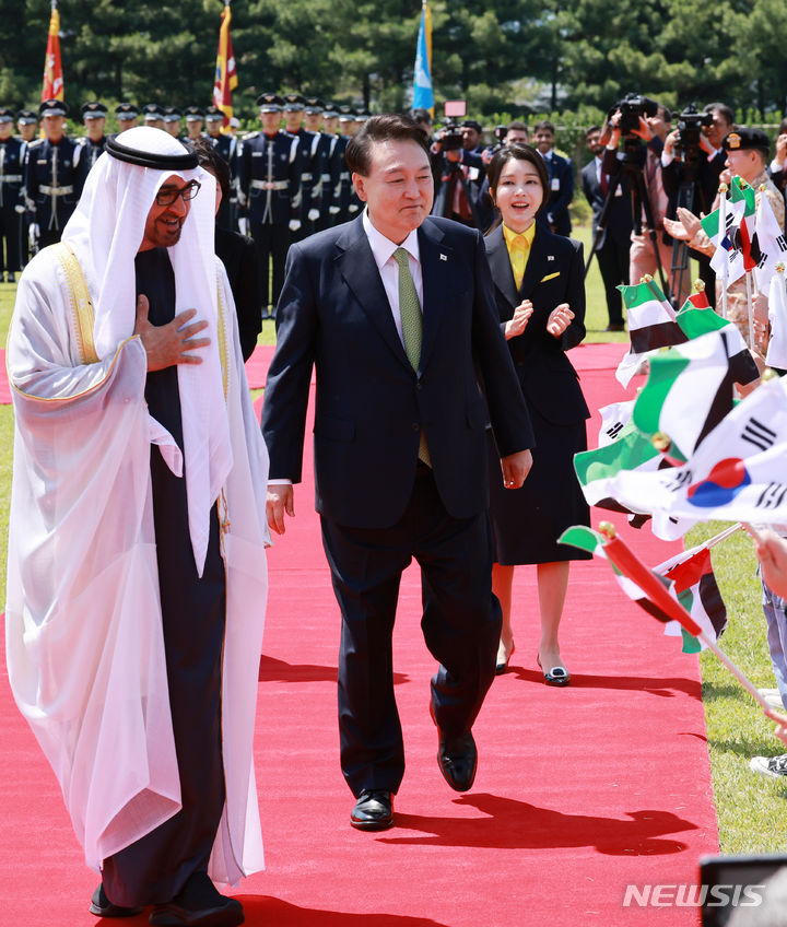 [서울=뉴시스] 조수정 기자 = 윤석열 대통령과 무함마드 빈 자예드 알 나흐얀 아랍에미리트연합국(UAE) 대통령이 29일 서울 용산 대통령실 잔디마당에서 열린 국빈 방한 공식 환영식에서 양국 국기를 들고 맞이하는 어린이환영단에 화답하고 있다. 윤 대통령 뒤는 부인 김건희 여사. (대통령실통신사진기자단) 2024.05.29. chocrystal@newsis.com