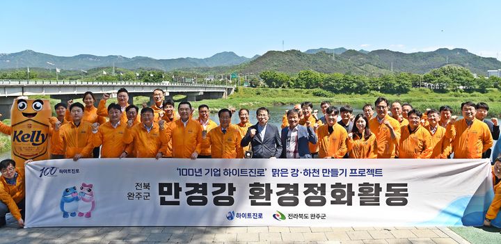 하이트진로는 13일 전북 완주군 만경강에서 김인규 하이트진로 대표(앞줄 왼쪽 네번째), 유희태 완주군 군수(앞줄 왼쪽 다섯 번째) 등 임직원들이 참석한 가운데 만경강 환경정화활동을 진행했다. (사진=하이트진로 제공) *재판매 및 DB 금지