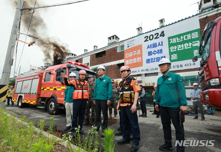 [서울=뉴시스] 고범준 기자 = 오세훈 서울시장이 30일 오후 서울 영등포구 신길동에서 열린 2024 서울시 풍수해 종합훈련 현장을 찾아 관계자로부터 훈련 설명을 듣고 있다. 2024.05.30. bjko@newsis.com