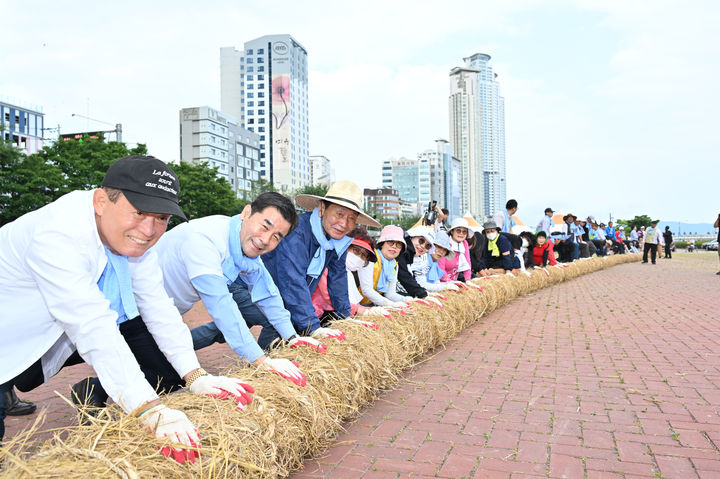 [울산=뉴시스] 태화강마두희축제추진위원회가 1일 태화강 체육공원에서 김영길 중구청장과　참석자들이　태화강마두희축제 울산마두희 큰줄당기기에 쓰일 ‘마두희 몸통 줄’ 제작을 하고　있다．(울산시 중구 제공) *재판매 및 DB 금지