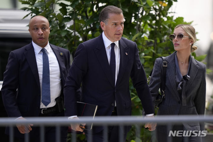 [AP/뉴시스] 조 바이든 대통령의 차남 헌터 바이든이 3일 자신의 총기불법 구입 연방재판에 출두하기 위해 부인과 함께 델라웨어주 윌밍턴 법원으로 가고 있다 