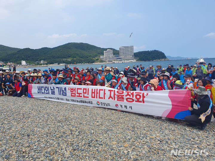 [창원=뉴시스]3일 경남 거제시 장목면 농소몽돌해변에서 열린 경남도와 거제시 주최 바다의 날 기념 대도민 해변정화 활동에 참여한 경남도 최만림 행정부지사와 어업인, 자원봉사자, 지역민, 수협, 공공기관, 민간단체, 공무원 등이 기념촬영하고 있다.(사진=경남도 제공) 2024.06.03. photo@newsis.com