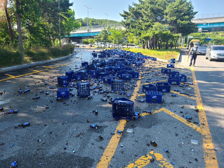 [울산=뉴시스] 박수지 기자 = 3일 오후 울산시 남구 감나무진사거리에서 화물트럭에 적재돼 있던 맥주병 약 9t이 도로 위로 떨어져 있다. (사진=울산경찰청 제공) 2024.06.03. photo@newsis.com *재판매 및 DB 금지